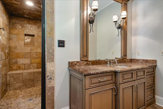 a bathroom with a granite countertop sink a mirror and a shower