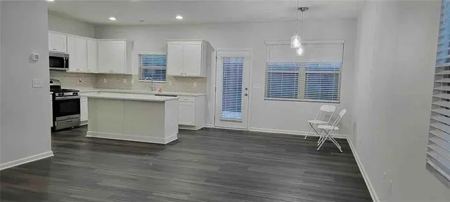 a kitchen with stainless steel appliances granite countertop a stove a sink dishwasher and a microwave oven with wooden floor