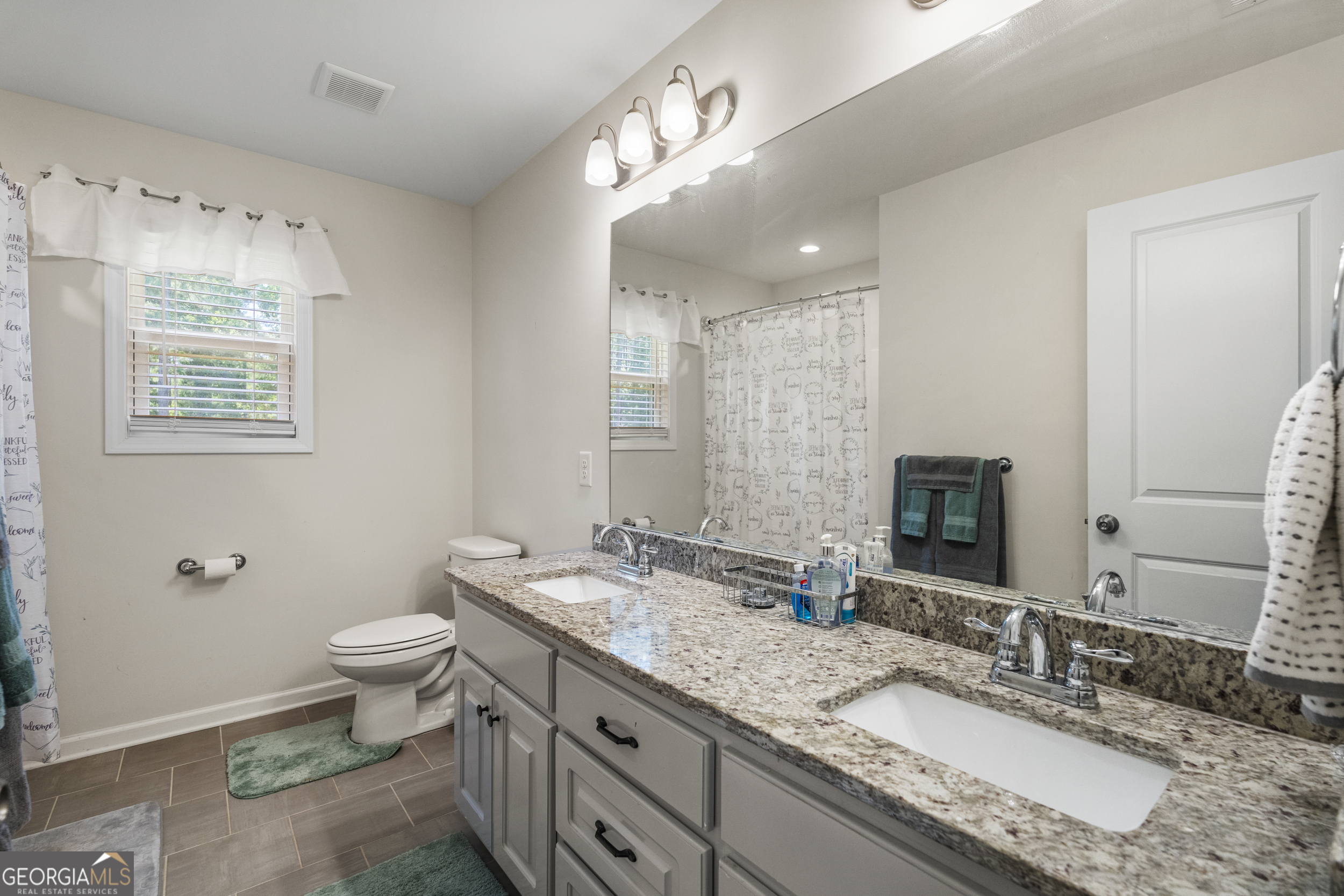 209 Marsh Road West Point, GA 31833 - Photo 18 of 50 a bathroom with a granite countertop double vanity sink a mirror and a toilet
