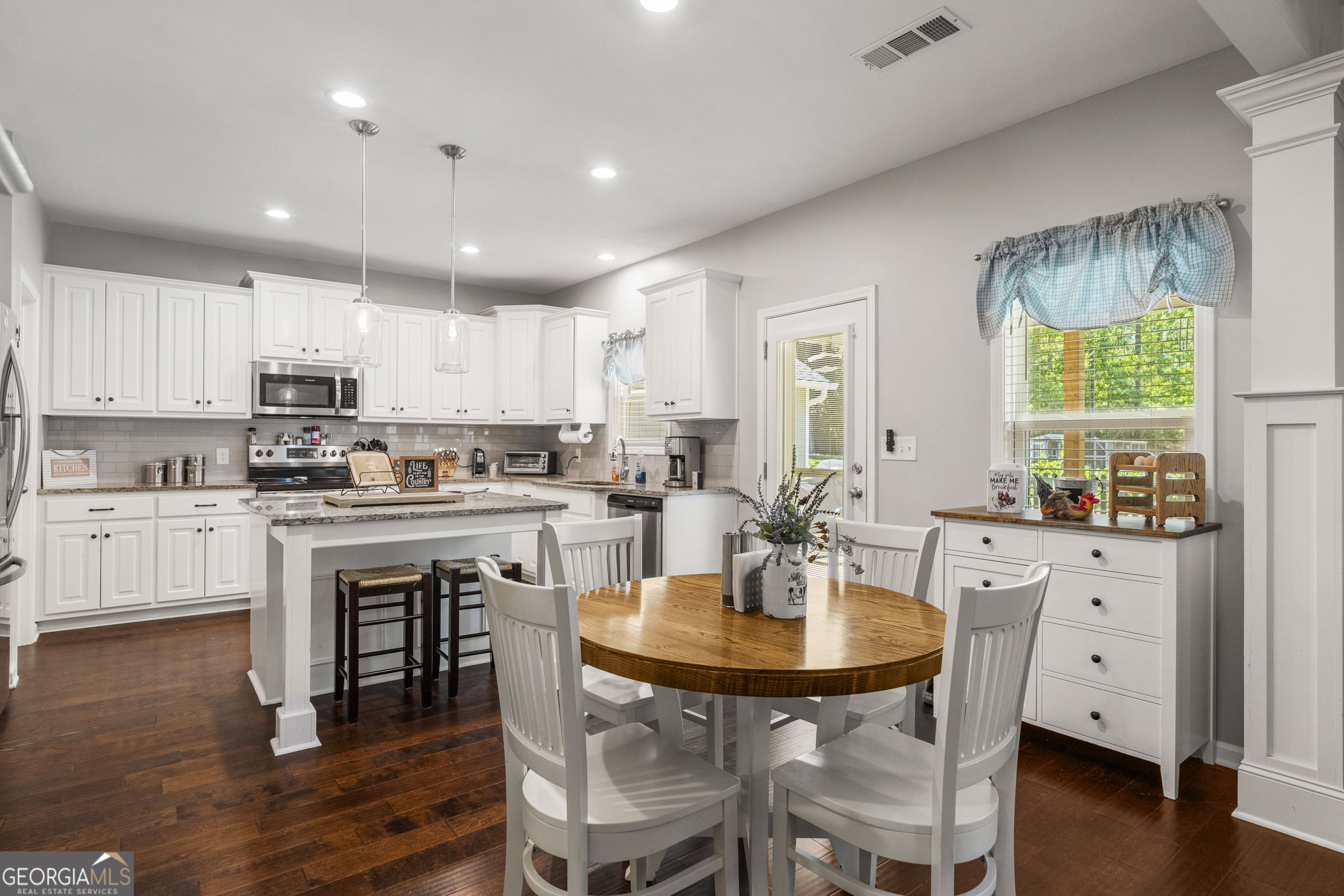 209 Marsh Road West Point, GA 31833 - Photo 6 of 50 a kitchen with a dining table chairs and white cabinets