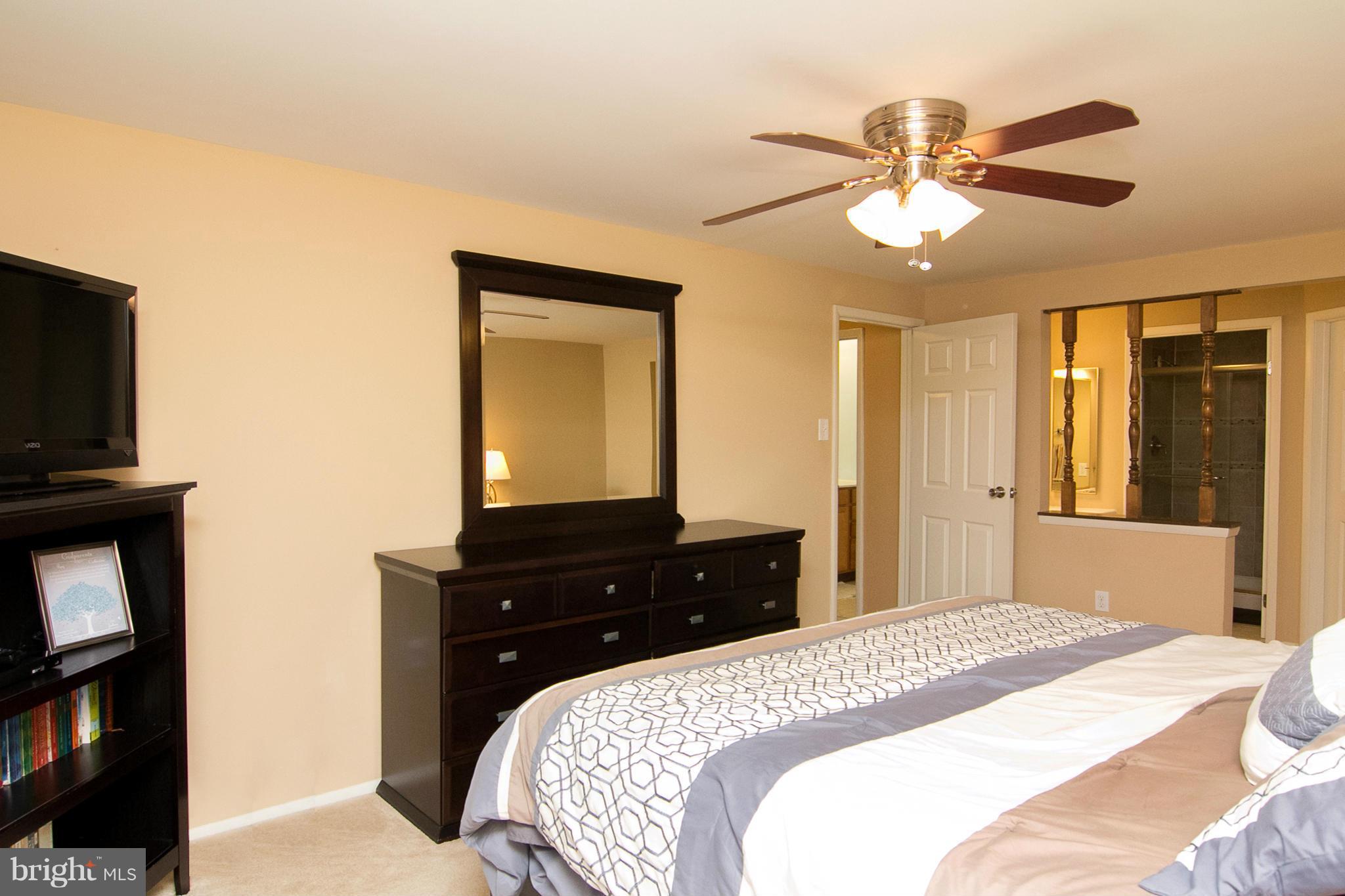 343 Timber Grove Road Owings Mills, MD 21117 - Photo 14 of 29 a bedroom with a bed and a flat tv screen on dresser