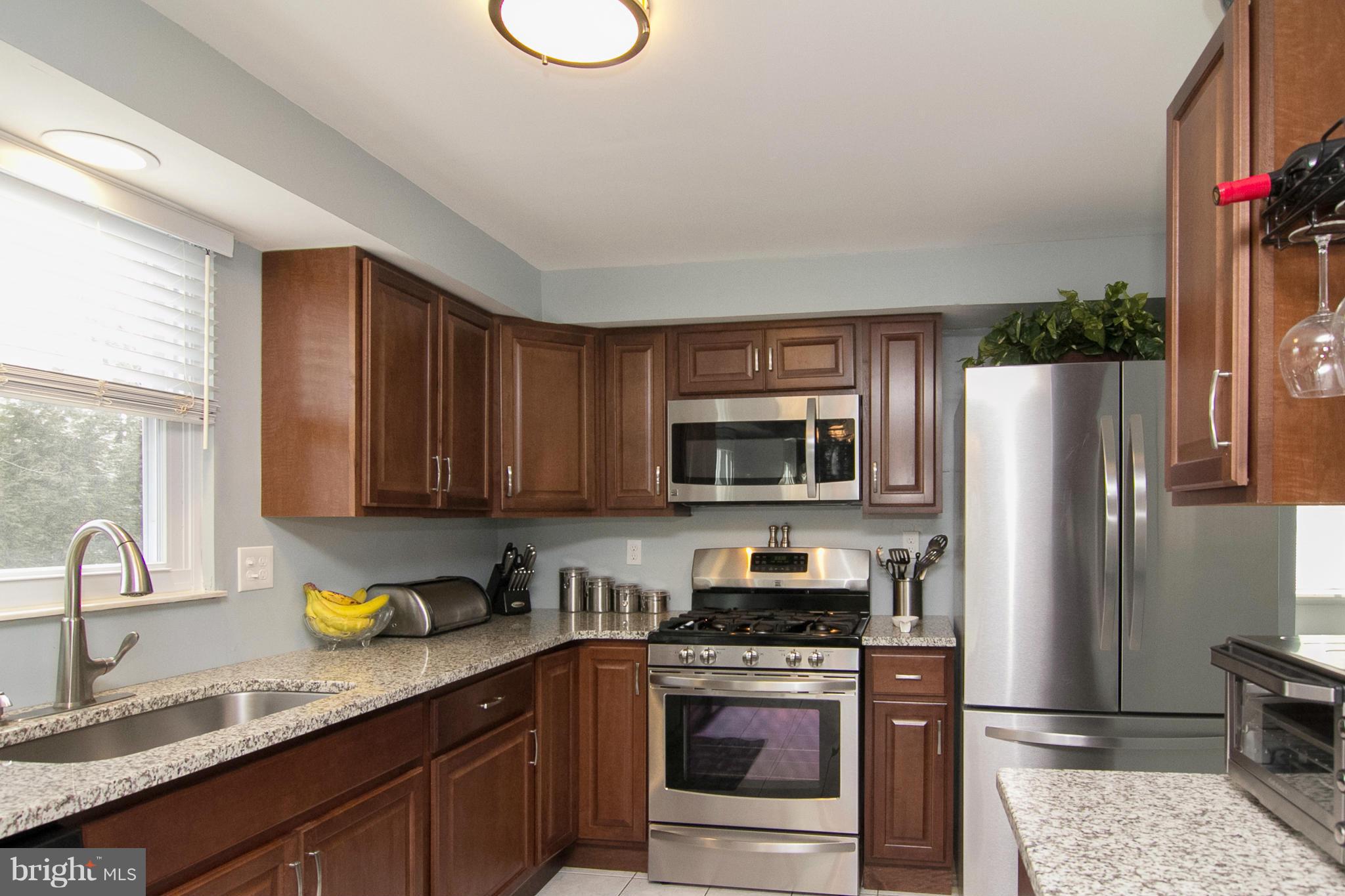 343 Timber Grove Road Owings Mills, MD 21117 - Photo 3 of 29 a kitchen with stainless steel appliances granite countertop a stove a sink dishwasher a microwave oven with granite countertops and cabinets