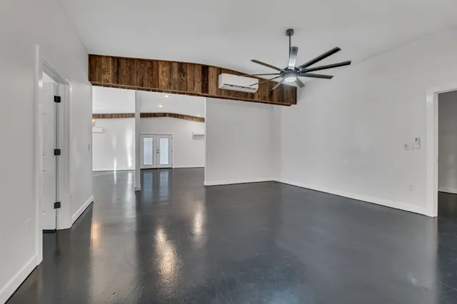 a view of a livingroom with wooden floor a ceiling fan and staircase