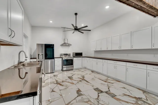 a kitchen with stainless steel appliances granite countertop a sink a stove and cabinets