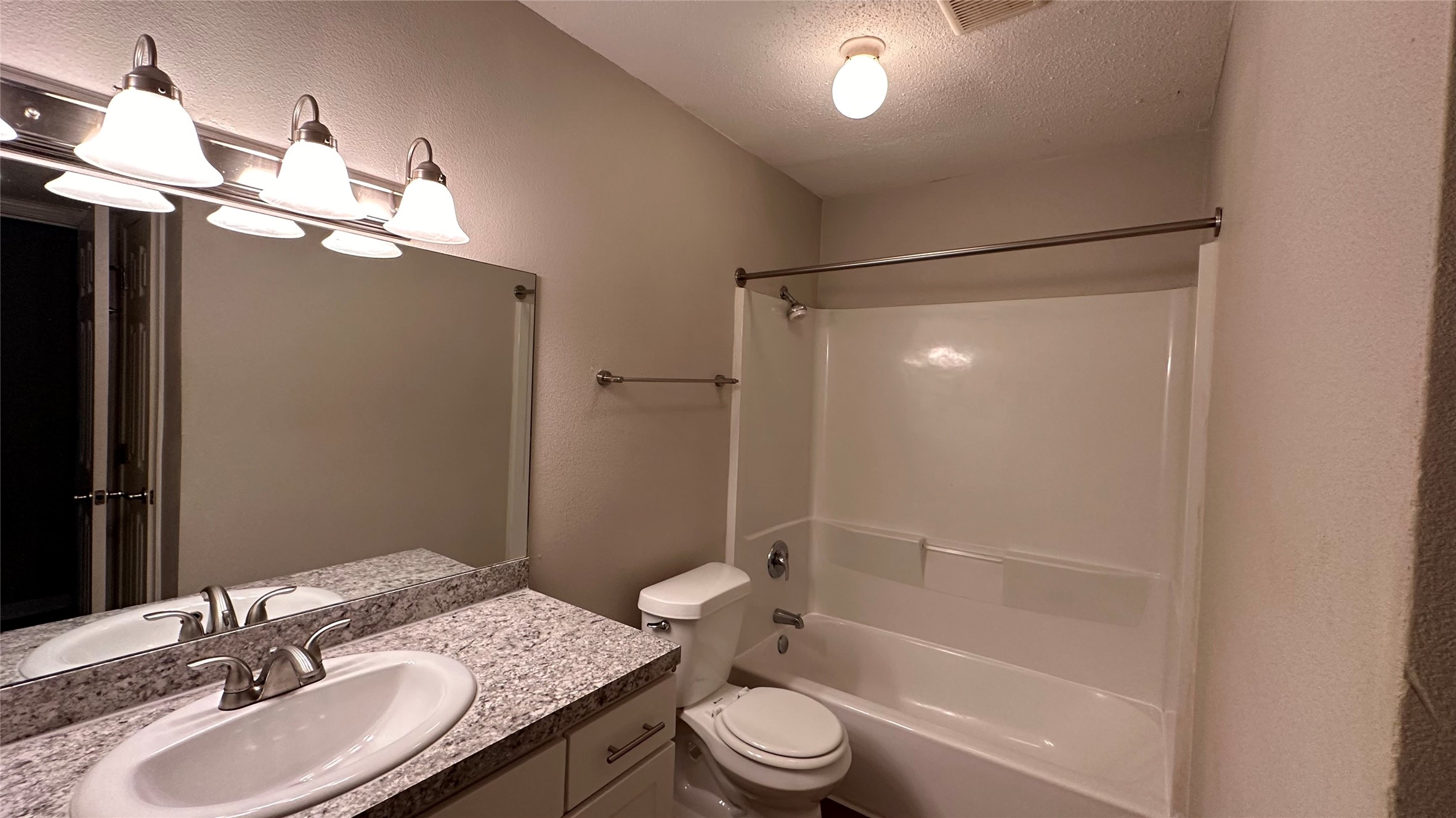 a bathroom with a granite countertop sink toilet and shower