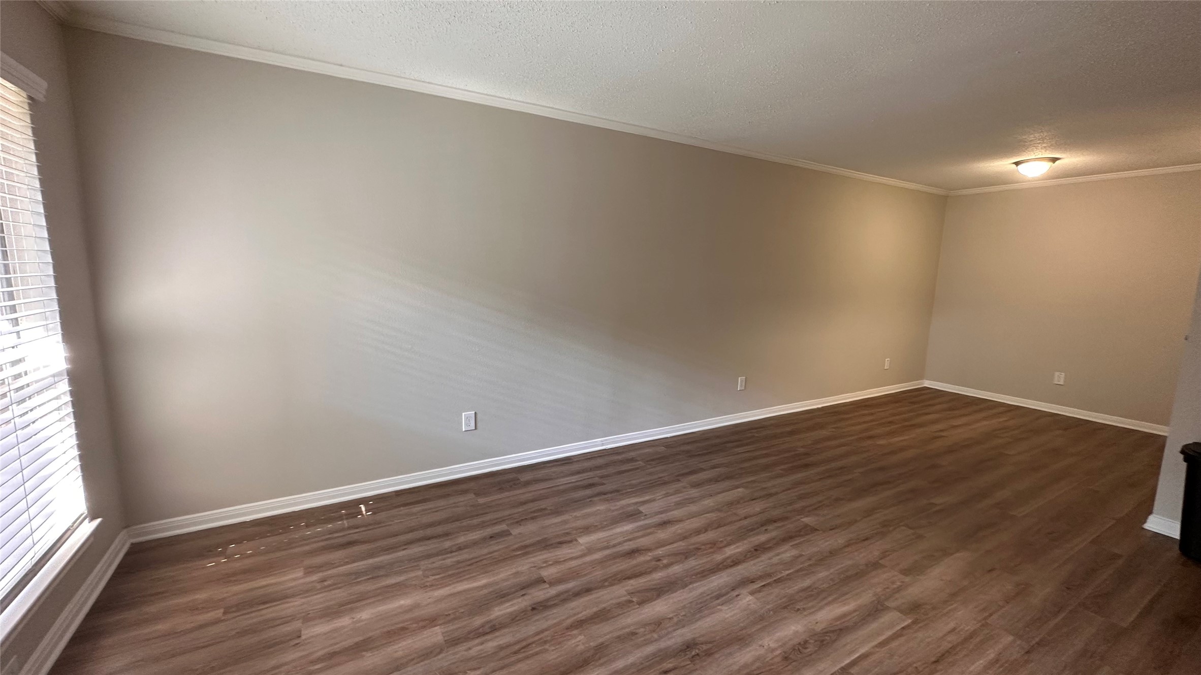 7315 Brompton Street, Unit 127B Houston, TX 77025 - Photo 6 of 13 a view of an empty room with wooden floor and a window