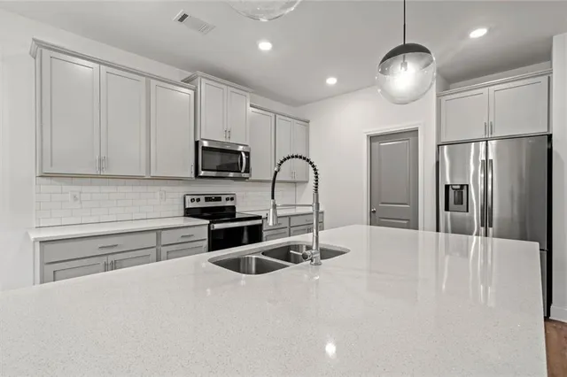 a kitchen with granite countertop a refrigerator stove and microwave