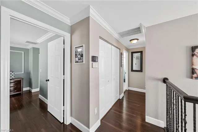 a view of a hallway with wooden floor and a living room