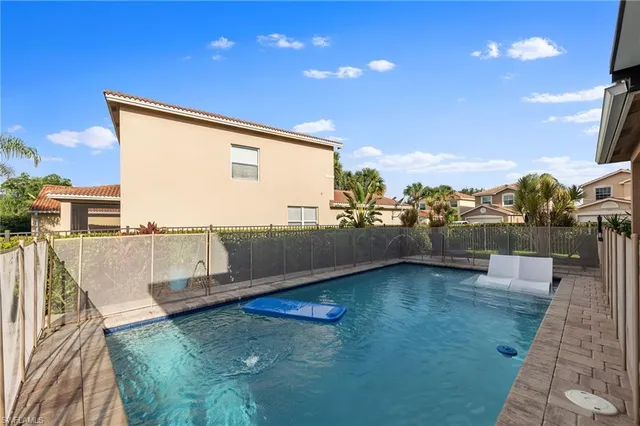 a view of a house with pool and chairs