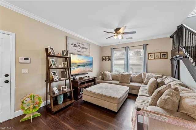 a living room with furniture a flat screen tv and a large window