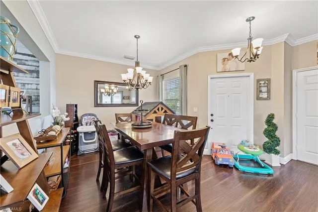 a view of a dining room with furniture wooden floor and chandelier