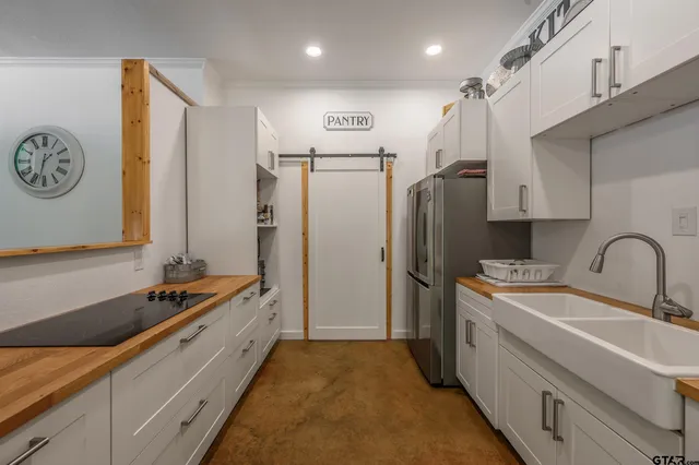 a kitchen with stainless steel appliances granite countertop a sink refrigerator and cabinets