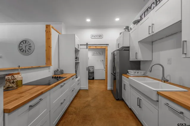 a large kitchen with a sink and refrigerator