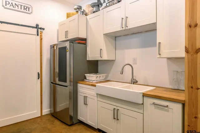 a kitchen with stainless steel appliances a refrigerator sink and cabinets
