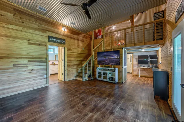 a view of an empty room with wooden floor and a fireplace