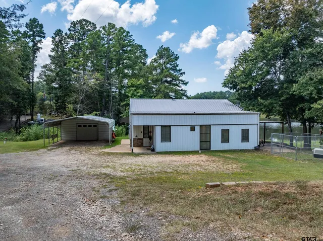 a view of a house with a yard and large tree