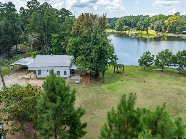 an aerial view of a house with garden space and lake view