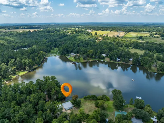 an aerial view of a house with a yard and lake view