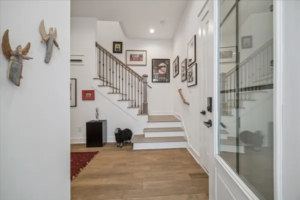 a view of staircase with lots of frames on wall and a table