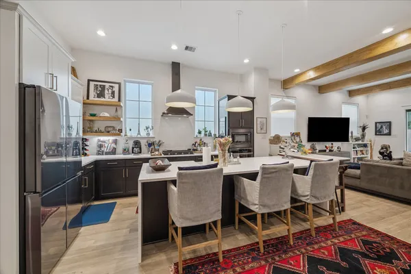 a kitchen with stainless steel appliances kitchen island granite countertop a table chairs microwave and sink