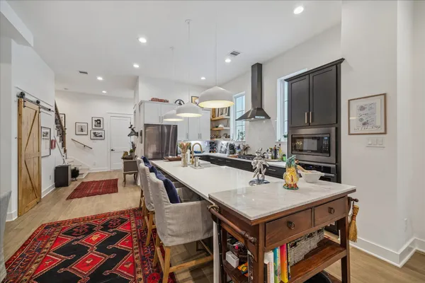 a kitchen with a stove a refrigerator and a dining table