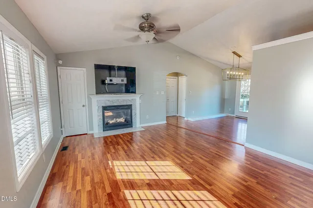 a view of empty room with a fireplace and wooden floor