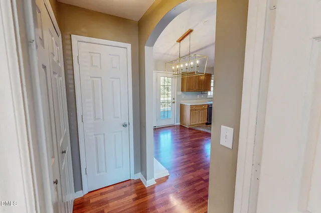 a view of a hallway with wooden floor and kitchen