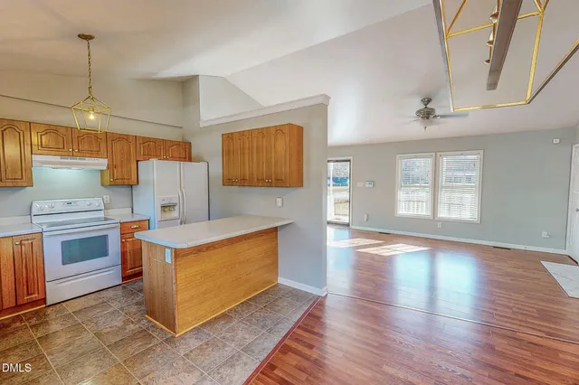 a kitchen with stainless steel appliances granite countertop a sink a stove and a wooden floors