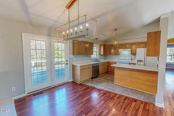 a large kitchen with granite countertop a large counter top space a sink stainless steel appliances and cabinets