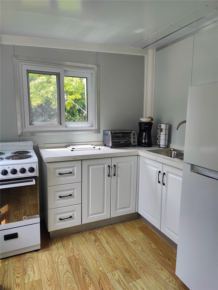 16475 Southwest 248th Street, Unit C Homestead, FL 33031 - Photo 2 of 6 a kitchen with a stove a sink and a window
