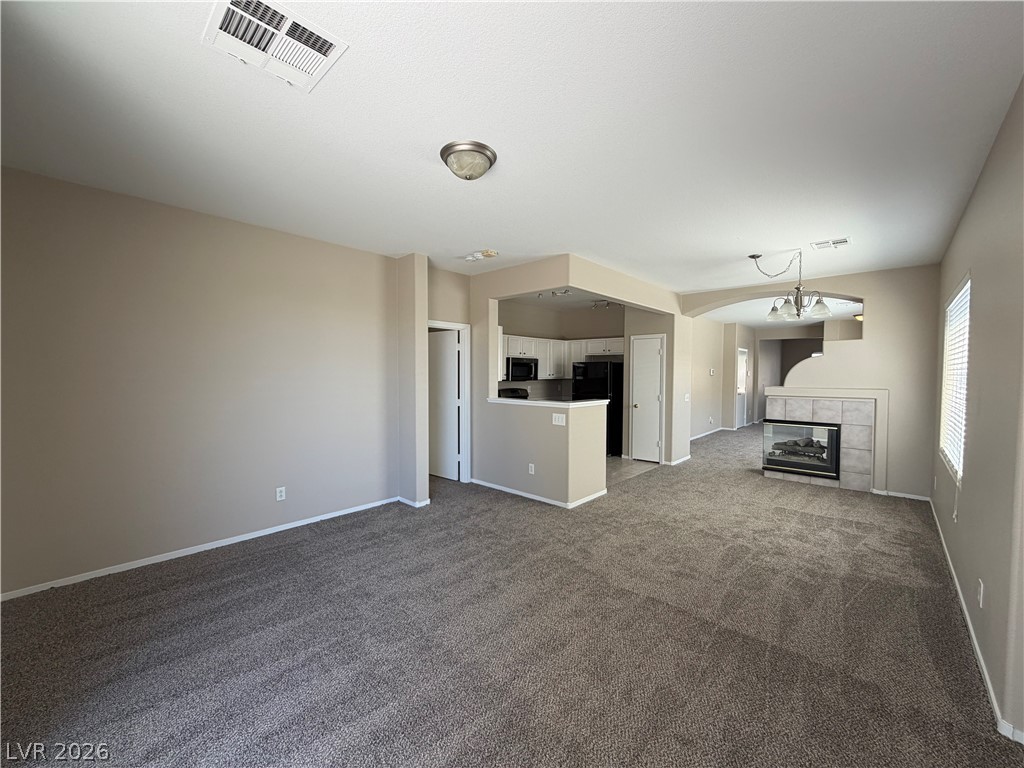 10975 Pumpkin Ridge Avenue Las Vegas, NV 89135 - Photo 3 of 13 An inviting open-concept living space features a cozy fireplace and seamless flow to the kitchen.