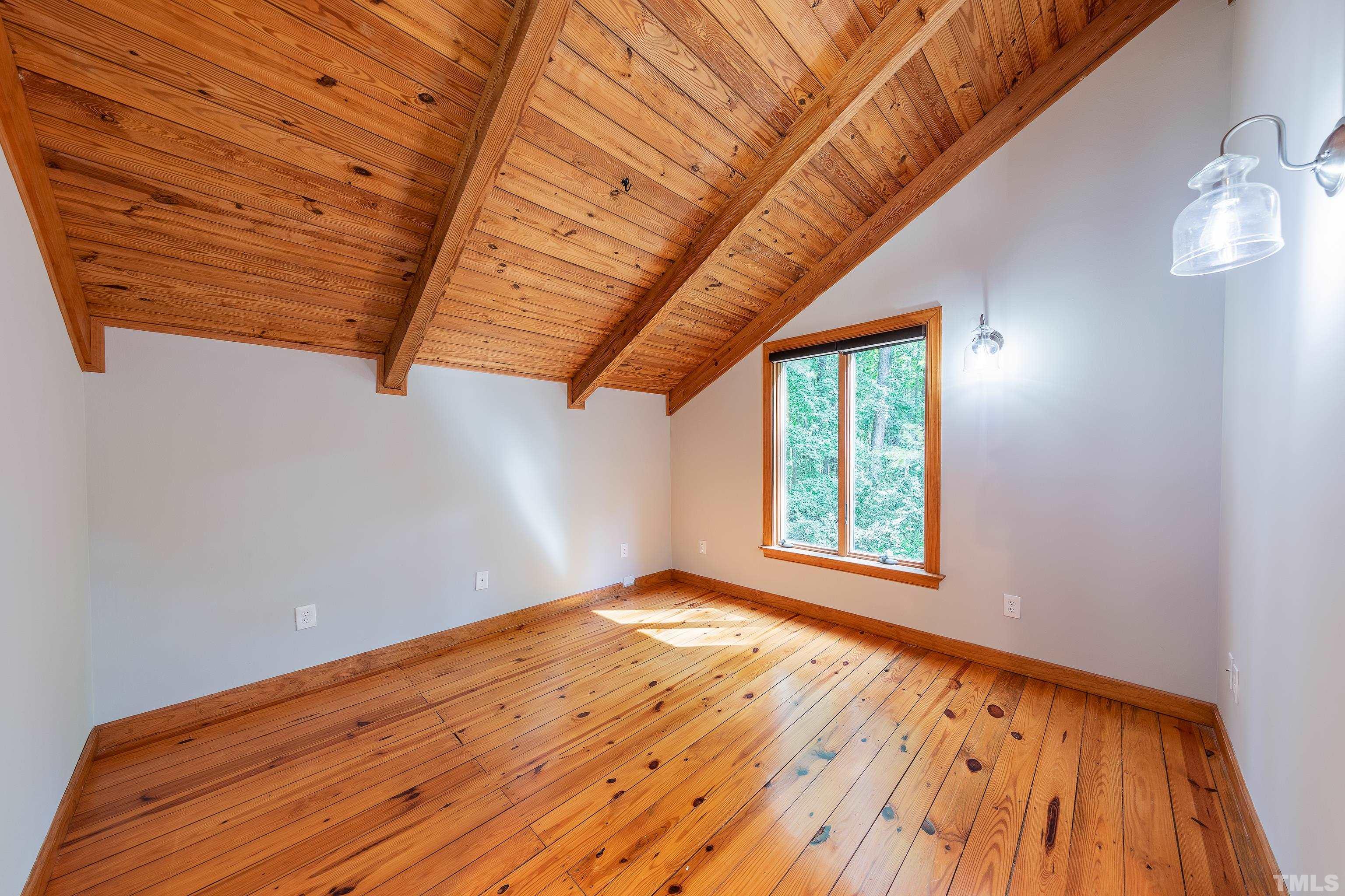 12217 Old Creedmoor Road Raleigh, NC 27613 - Photo 14 of 41 a view of an empty room with wooden floor and a window