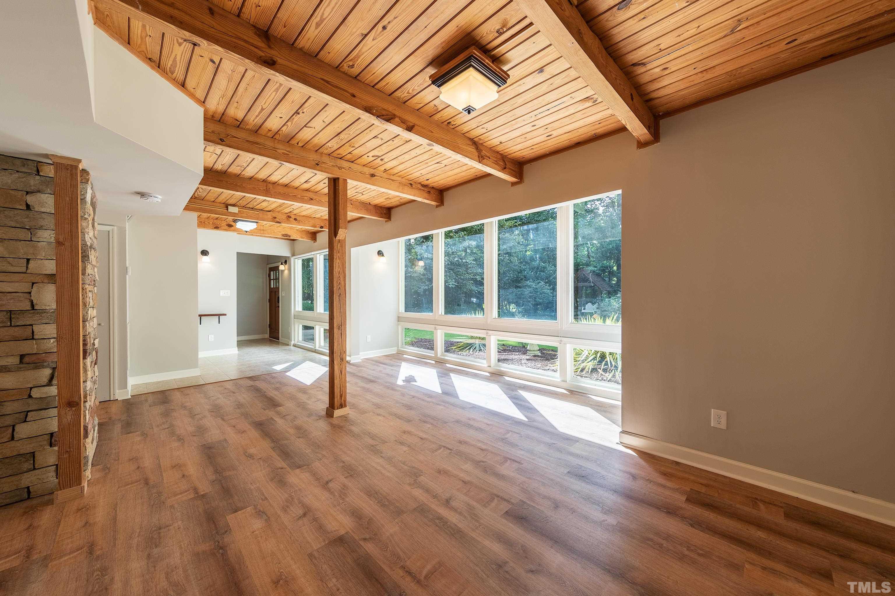 12217 Old Creedmoor Road Raleigh, NC 27613 - Photo 5 of 41 an empty room with wooden floor and windows