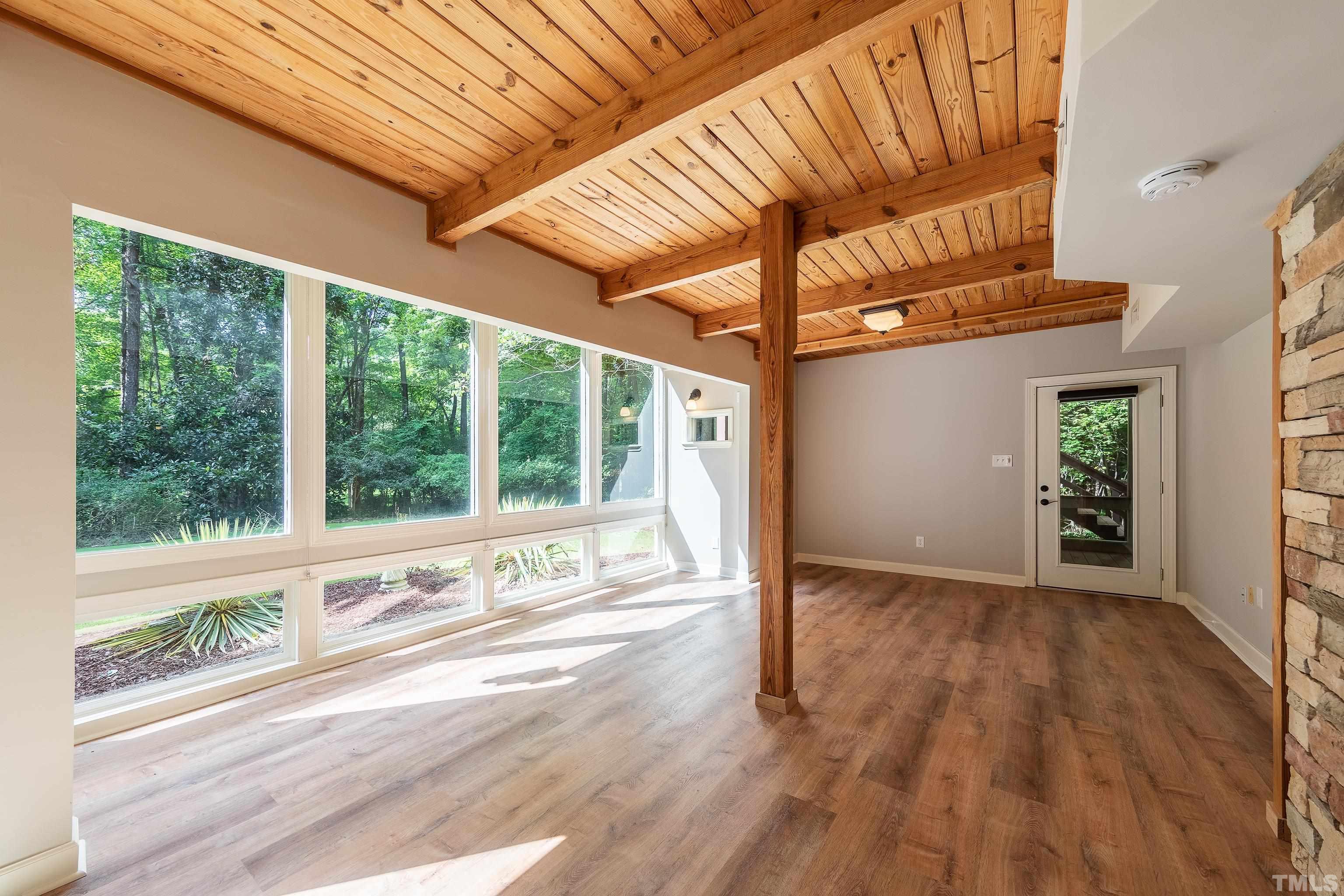 12217 Old Creedmoor Road Raleigh, NC 27613 - Photo 6 of 41 a view of an empty room with wooden floor and a window