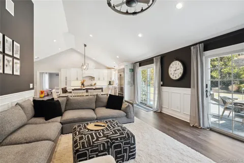 a living room with furniture a rug and white walls