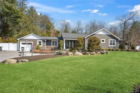 a front view of a house with a garden and yard