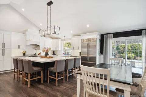 a dining room with furniture a chandelier and wooden floor