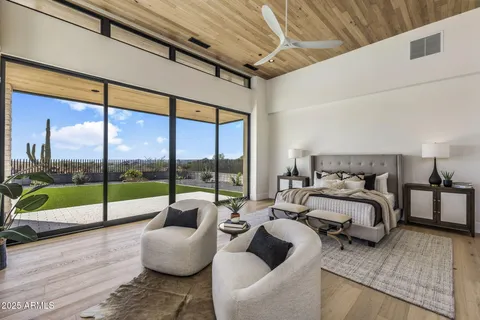 a spacious bedroom with furniture and a large window