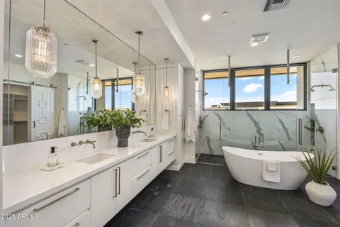 a bathroom with a double vanity sink a mirror and a bathtub