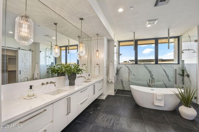 a bathroom with a double vanity sink a mirror and a bathtub