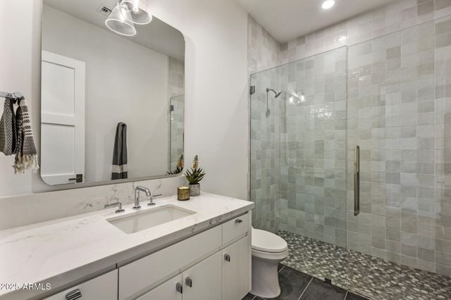 a bathroom with a sink toilet a mirror and shower