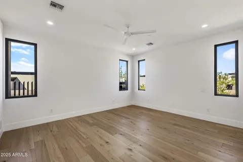 an empty room with wooden floor and windows