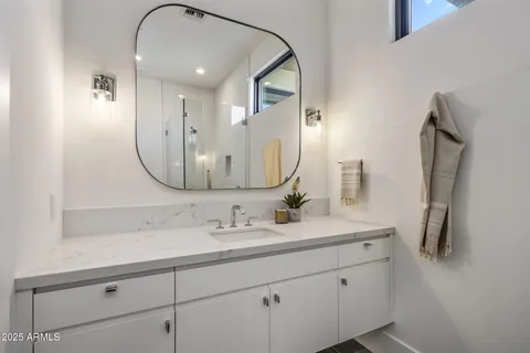 a bathroom with a sink vanity and a mirror