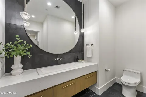 a bathroom with a toilet sink and mirror