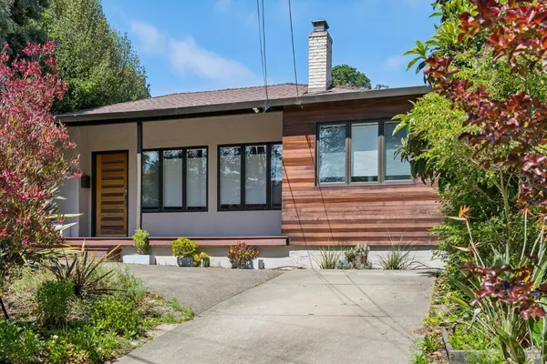 a front view of a house with a garden