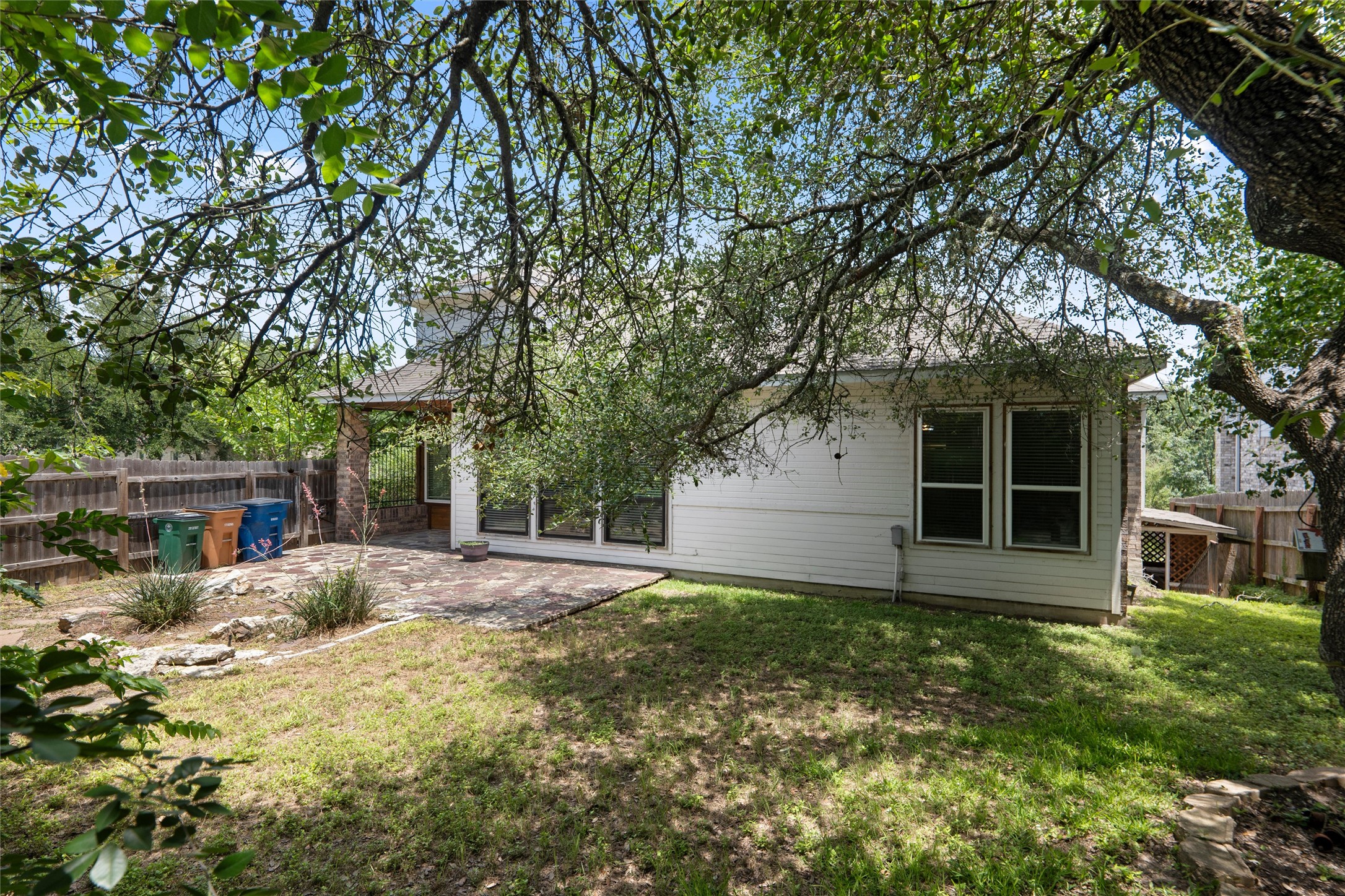 7000 Colberg Court Austin, TX 78749 - Photo 38 of 40 A quaint backyard with a paver patio and ample natural shade from mature trees.
