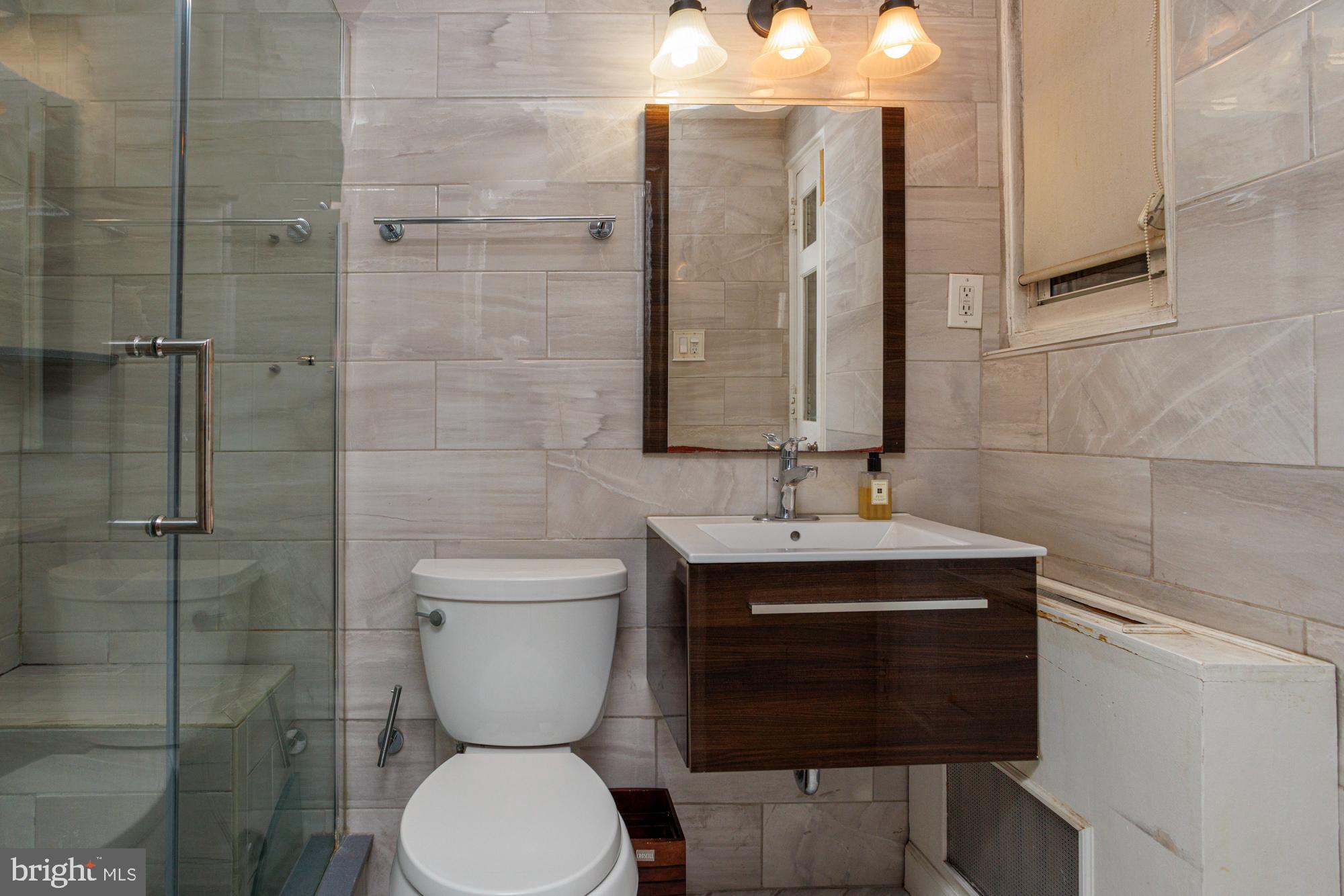 1901 Walnut Street, Unit 2E Philadelphia, PA 19103 - Photo 12 of 21 a bathroom with a toilet a sink and mirror