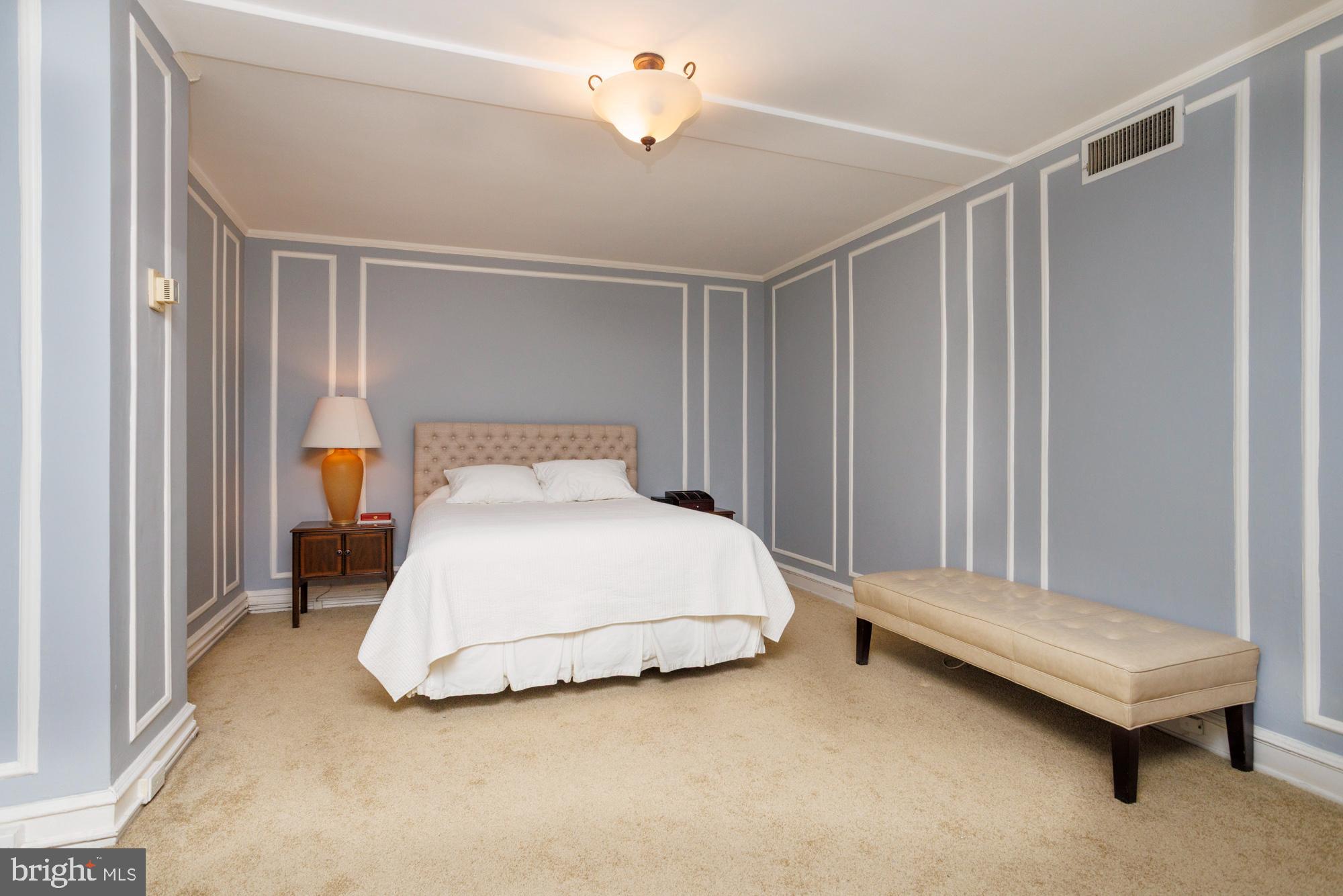 1901 Walnut Street, Unit 2E Philadelphia, PA 19103 - Photo 14 of 21 a bedroom with a bed and a chandelier
