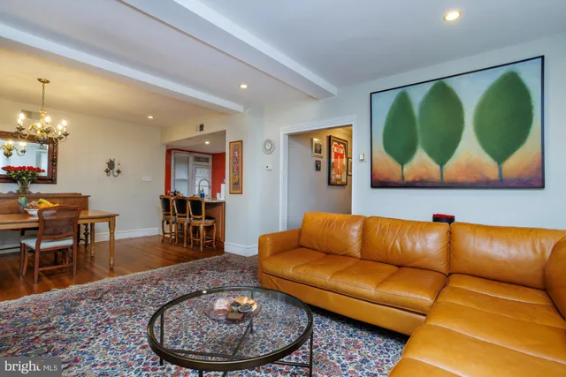 a living room with furniture a rug and a painting on the wall