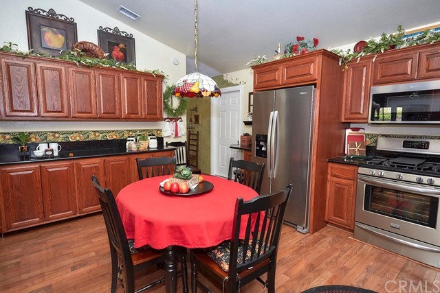 20058 Rancherias Lane Apple Valley, CA 92307 - Photo 33 of 83 a kitchen with stainless steel appliances a dining table chairs and refrigerator
